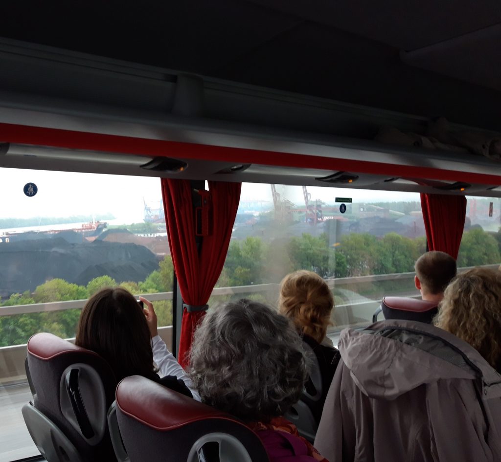 Gäste im Reisebus mit Blick auf Hafen